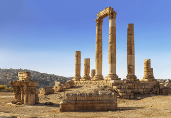 The ruins of the Temple of Hercules in Amman, the ancient fortress on a background of the urban landscape, Jordan