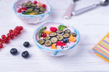 Whipped quark mousse with raspberries, blueberries, red currant and fizalis on a white background. Free space