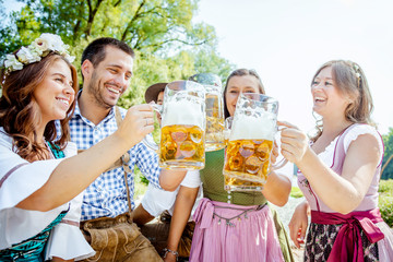 Freunde Trinken Bier in der Bayerischer Tracht an der Isar