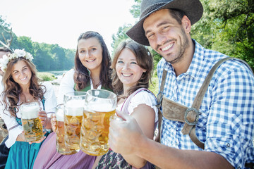 Freunde Trinken Bier in der Bayerischer Tracht an der Isar