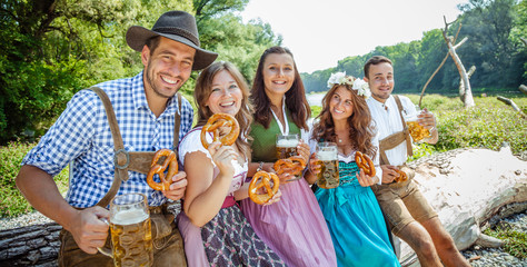 Freunde Trinken Bier in der Bayerischer Tracht an der Isar