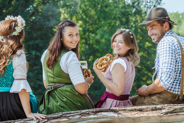 Freunde Trinken Bier in der Bayerischer Tracht an der Isar