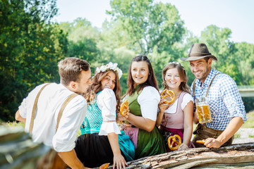 Freunde Trinken Bier in der Bayerischer Tracht an der Isar