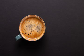 Cup of coffee on black background. Copy space. Top view. Flat lay.