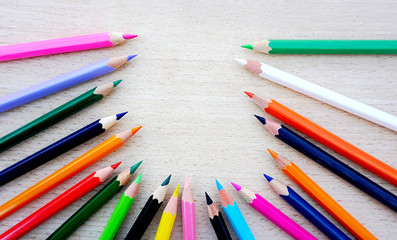 Fototapeta premium Crayon, wooden pencils in different color on the natural wood background