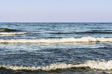 the blue sea with waves and foam, sea sky at sunset time, nature abstract background