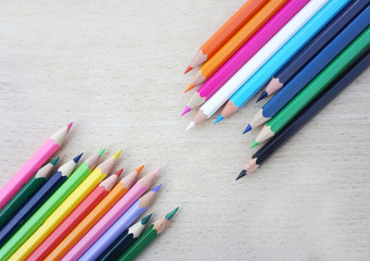 Wooden crayon in different color flat lay on wooden scratched background