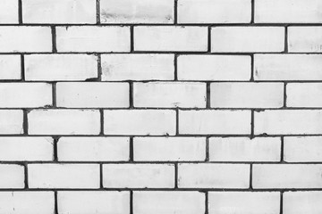 Fototapeta premium texture of a wall from a natural white brick with small cracks and chips, close-up abstract background