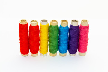 Standing colored thread coils on white background