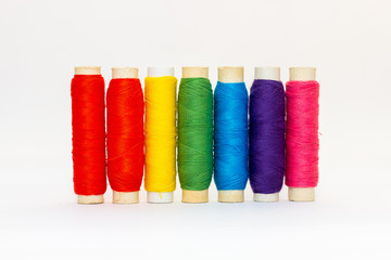Standing colored thread coils on white background