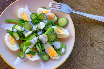 Dietary salad with chicken eggs, green onions, cucumbers and yogurt