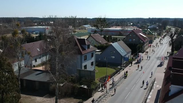 DEBNO, POLAND - APRIL 17, 2018: Participants running on the roads of Debno in the 45th edition of Marathon in Poland. Drone view