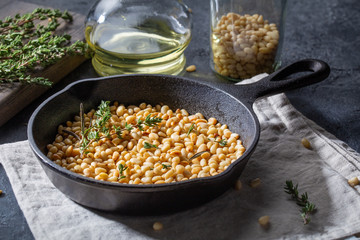 Pine nuts in frying pan, wood rustic style