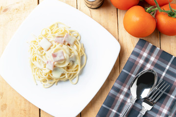 Spaghetti with cabonara sauce on white dish ,wood background