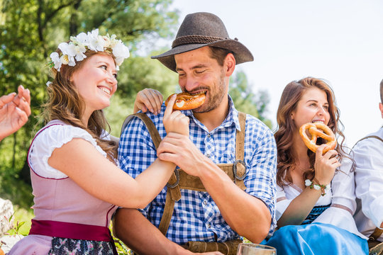 Freunde in trachtenmode entschpannen an der Isar