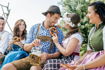 Freunde in trachtenmode entschpannen an der Isar