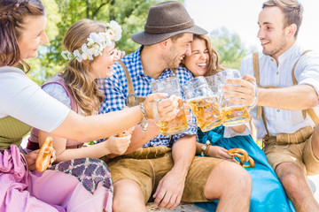 Freunde in trachtenmode entschpannen an der Isar