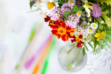 Picture / sketch of a bouquet of wildflowers in a transparent vase on a white background. Colour pencils. Glasses.