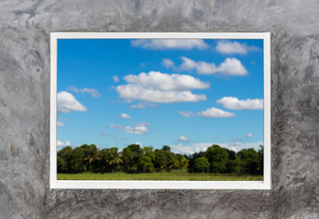 White window frames in concrete with rural sky clouds.