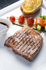 Close up Hida beef steak with grilled tomato, carrot, cucumber and asparagus on white plate