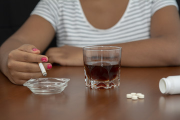 La mujer está fumando cigarrillos y bebiendo alcohol