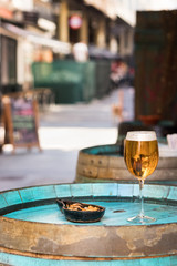 A glass with beer and mussels on a wooden wine barrel as a table.