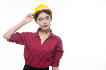 Beautiful engineering woman holding helmet with seriously face  in red shirt and yellow helmet with white background,