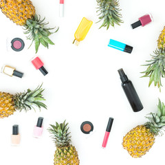 Frame made of pineapple fruits and female cosmetics on white background. Flat lay, top view.
