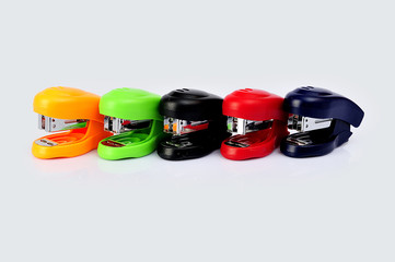 Staplers of different colors isolated on a white background.