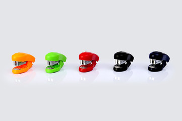 Staplers of different colors isolated on a white background.