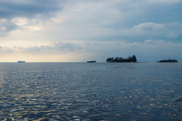 Flat small islands in front of Utila with dramatic cloudscape, Honduras, Central America