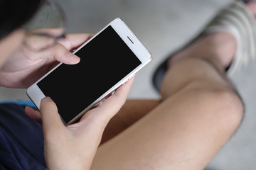 Cropped shot view of man hands holding smart phone with blank copy space screen for your text message or information content a rent time man sitting and using smartphone.