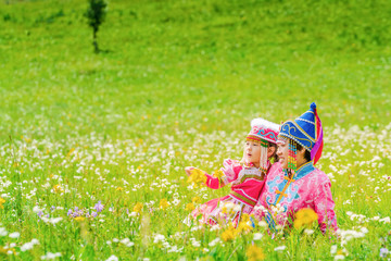 Mother and daughter dressed in Mongolian costumes on the grassland
