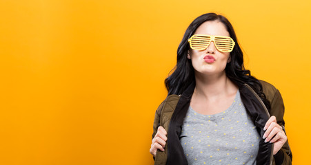 Fashionable woman with attitude in a bomber jacket on a golden yellow background