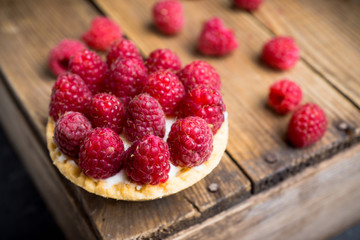 Rasberry cake decorated with fresh ripe berries on the rustic background. Selective focus. Shallow depth of field.