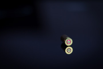 9 mm bullet shell.Bullet in shadow on a glass table