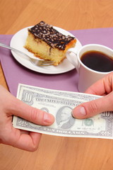 Paying for cheesecake and coffee in cafe using currencies dollar, finance concept