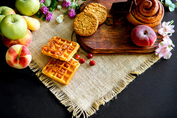 Homemade cinnamon buns in glaze on a dark plate with berries