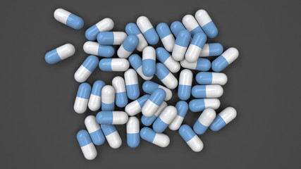 Pile of white and blue medicine capsules