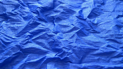 Bright blue background of crumpled paper