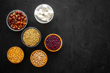 Products rich protein. Legumes, nuts, low-fat cheese. Raw beans, chickpeas, lentil, almond, hazelnut on black background top view space for text
