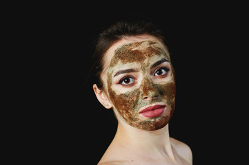 portrait of a young attractive woman in a cosmetic mask . Girl doing beauty treatments