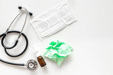 Flu drops. Running nose concept. Wrinkled napkin near stethoscope and face mask on white background top view copy space
