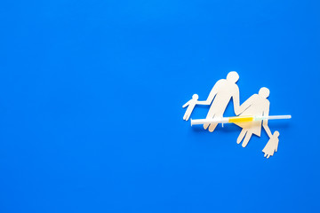 Vaccination for healthy family, vacctination of children. Flu. Syringe near family cutout on blue background top view copy space