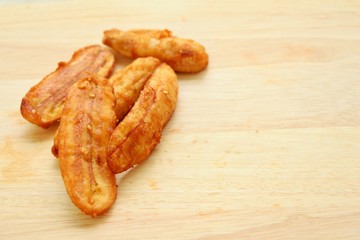 Fried banana with copy space on wood background.