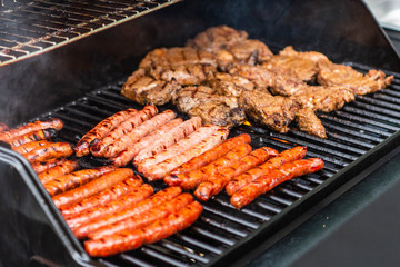 Barbecue grill bbq on propane gas grill steaks bratwurst sausages meat meal