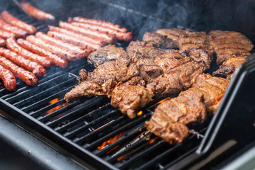 Barbecue grill bbq on propane gas grill steaks bratwurst sausages meat meal