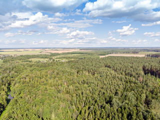 Fototapeta na wymiar nature landscape aerial photography. foliage forest, green fields and cloudy blue sky 