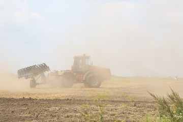 Naklejka premium The tractor is working in the field. 