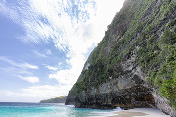 A cliff face and part of Kelingking Beach on Nusa Penida in Indonesia. - obrazy, fototapety, plakaty